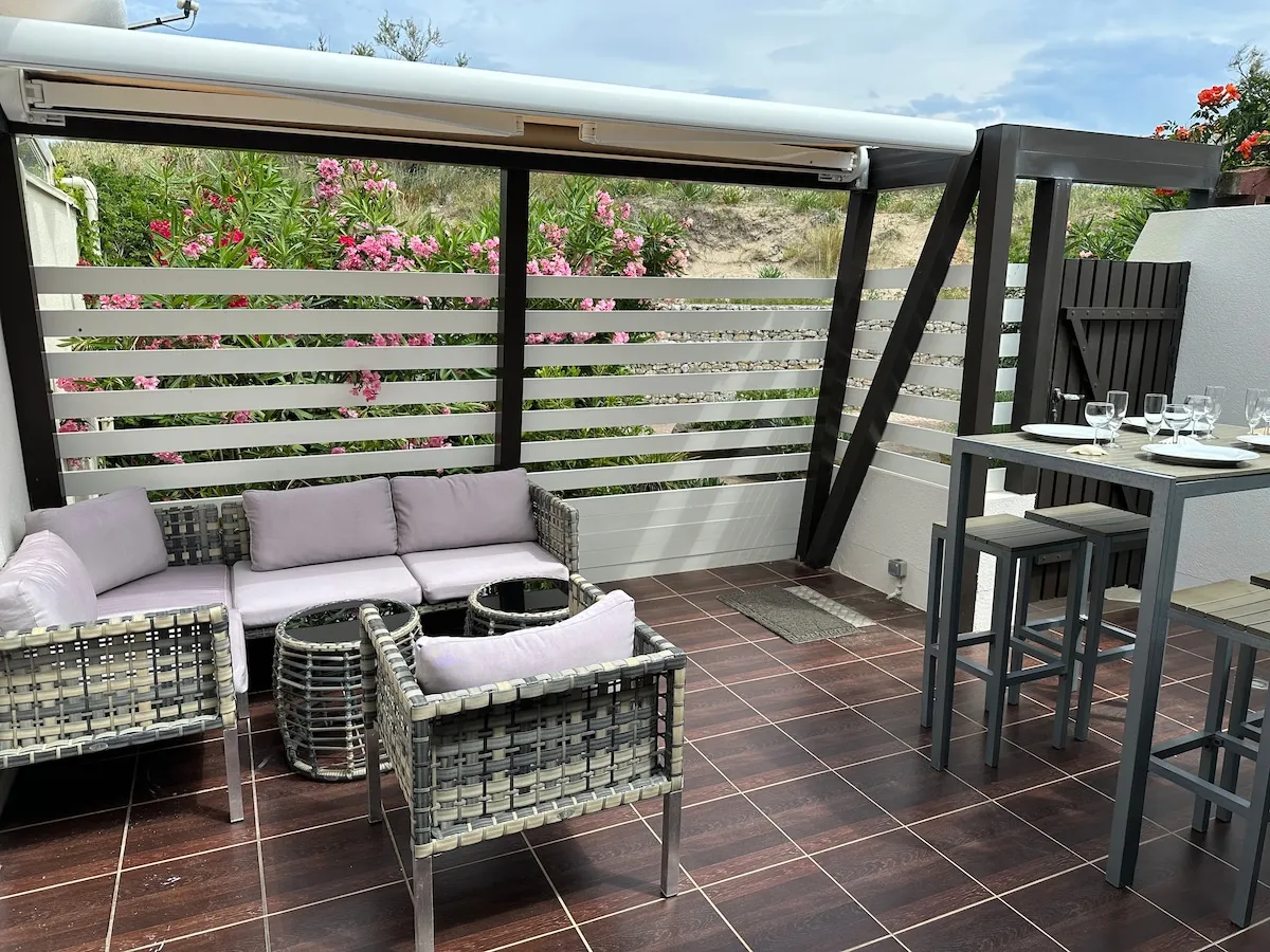 La terrasse de 20 m² et son salon de jardin abrité